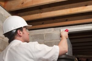 man in white hard hat spraying for pests