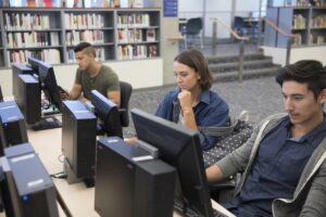 Young adults studying at library computers