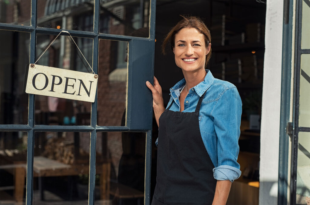 Business insurance for a woman holding open business door