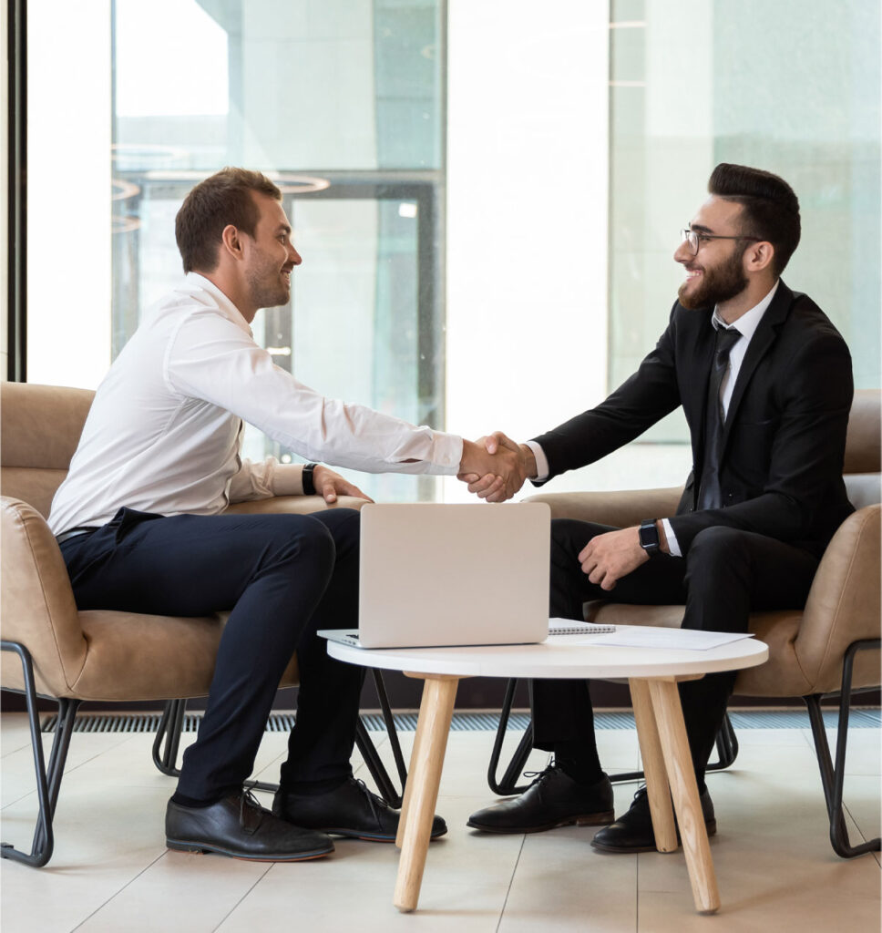 Two men shaking hands with laptop